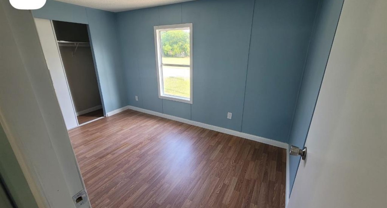 1403 Old Greens Road Houston, TX 77032 - Photo 9 of 19 an empty room with wooden floor and windows