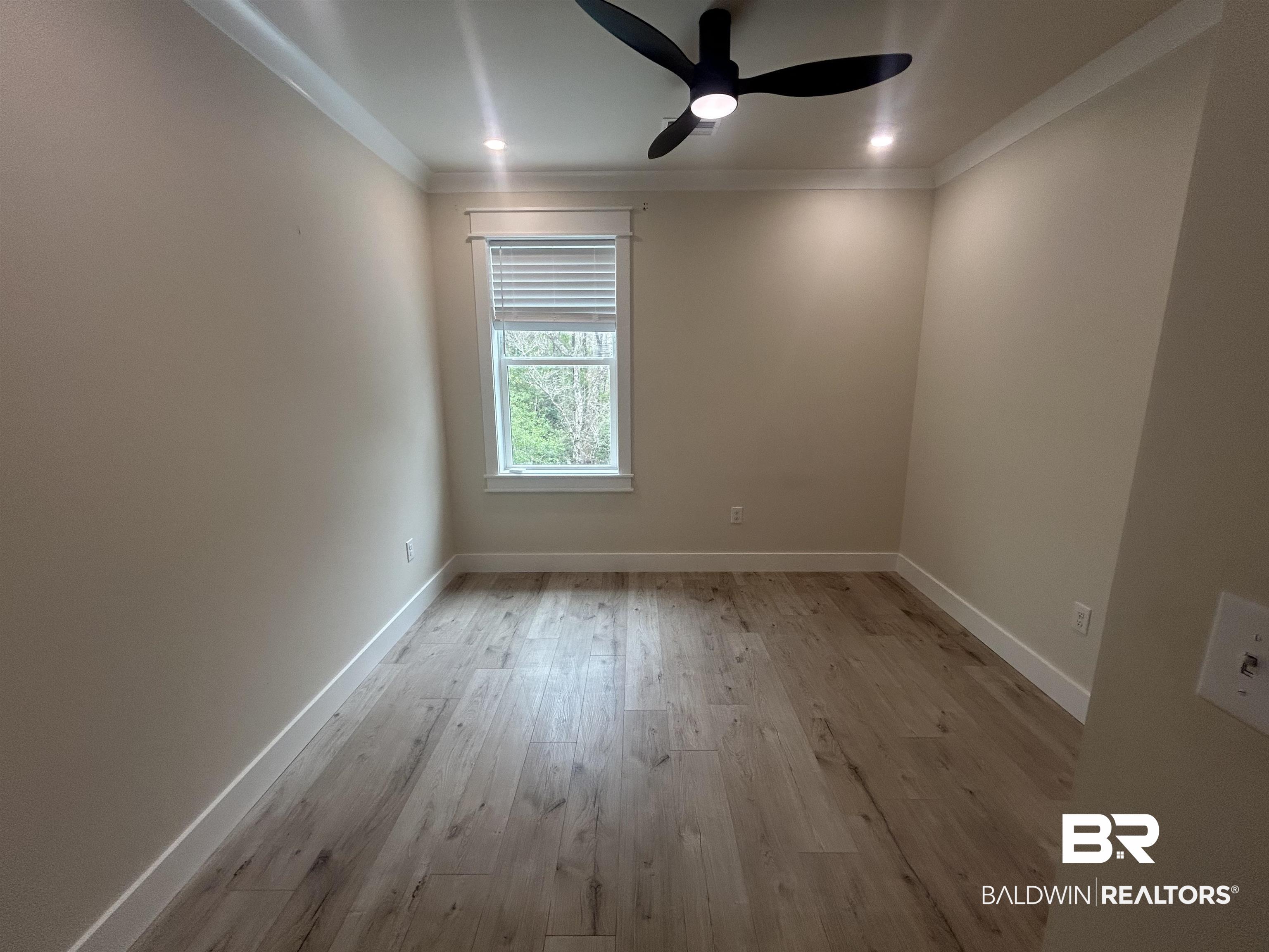 5122 Pine Road Orange Beach, AL 36561 - Photo 12 of 24 Unfurnished room with light wood-type flooring, a ceiling fan, and crown molding