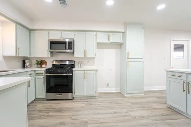 a kitchen with a refrigerator stove and white cabinets