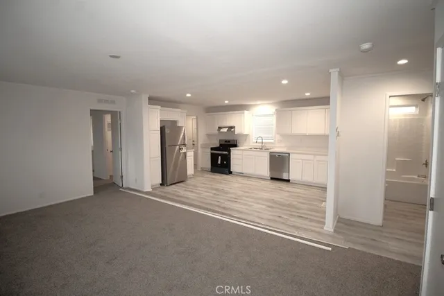 a view of a kitchen with a sink and a refrigerator