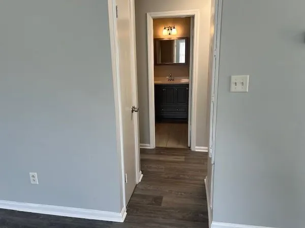 a view of a hallway with wooden floor and closet