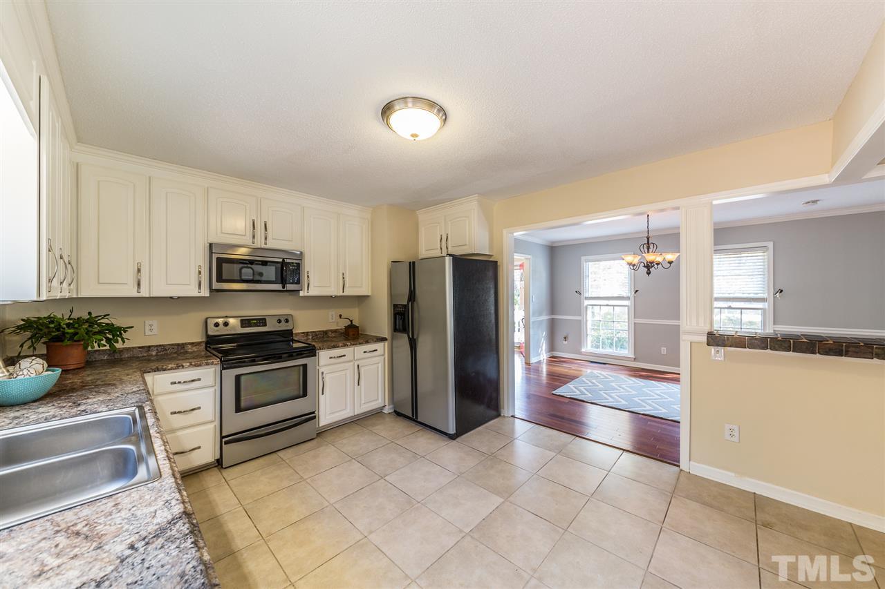 8236 Bells Lake Road Apex, NC 27539 - Photo 7 of 25 Chefs will love preparing meals in the light and bright kitchen. The stainless steel appliances, white cabinetry, and plenty of space to move around make this kitchen perfect for home cooking.