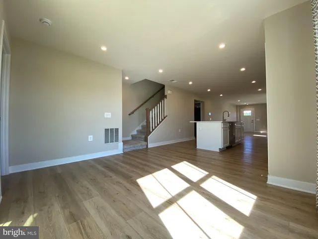 a spacious bathroom with a double vanity sink a toilet and a mirror