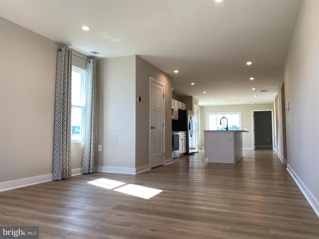 a view of an empty room with wooden floor