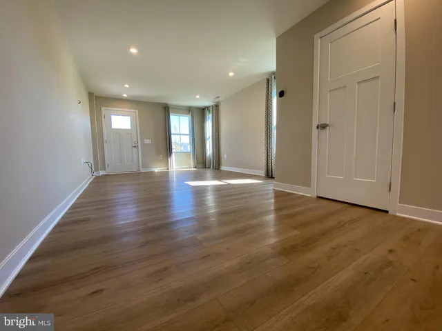 a kitchen with stainless steel appliances granite countertop a refrigerator a stove top oven a sink and dishwasher with wooden floor