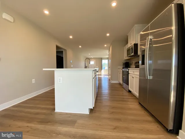 a view of kitchen with refrigerator and wooden floor