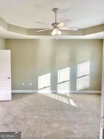 an empty room with a ceiling fan and window