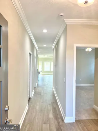 a view of a hallway with wooden floor