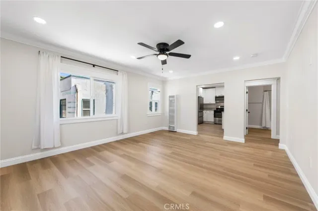a view of an empty room with a window and wooden floor