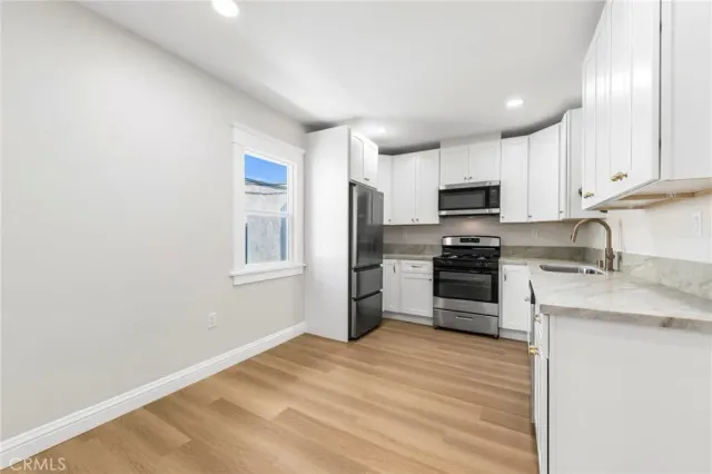 a kitchen with granite countertop a refrigerator stove and microwave