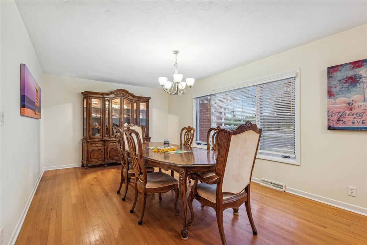 512 Busse Road Mount Prospect, IL 60056 - Photo 6 of 24 a dining room with furniture a chandelier and wooden floor