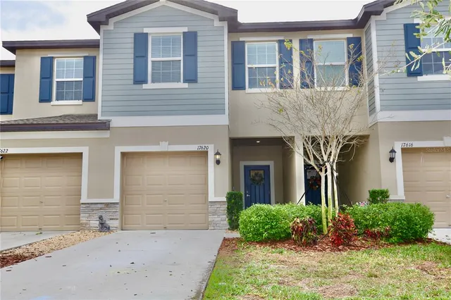 a kitchen with stainless steel appliances kitchen island granite countertop a dining table chairs and a refrigerator