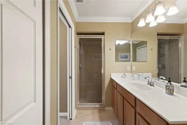 a bathroom with a double vanity sink mirror and shower