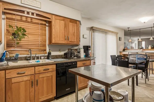 a kitchen with a sink a stove cabinets dining table and chairs