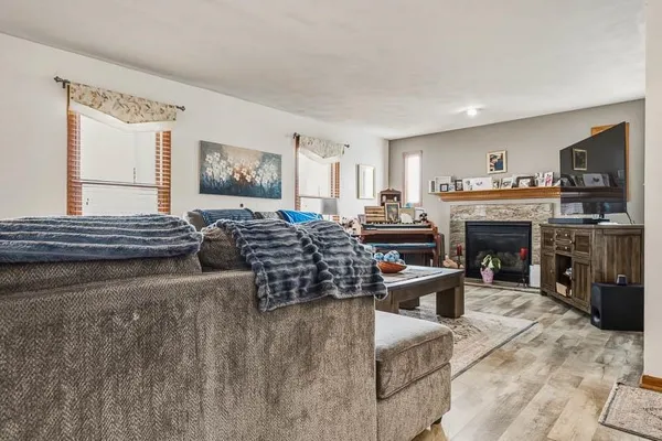 a living room with furniture a fireplace and a window