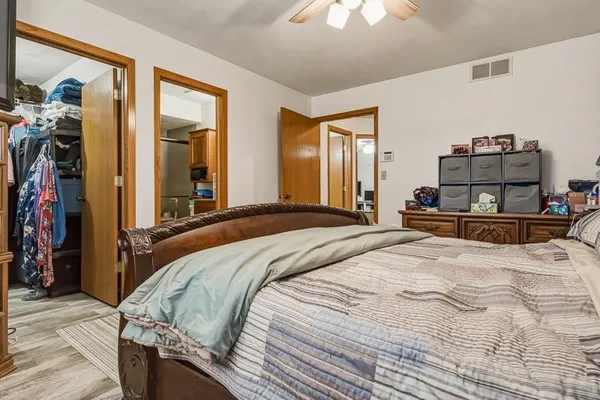 a bedroom with a bed and a mirror on dresser