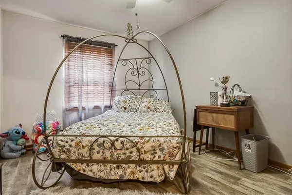 a bed sitting in a bedroom next to a window with chair