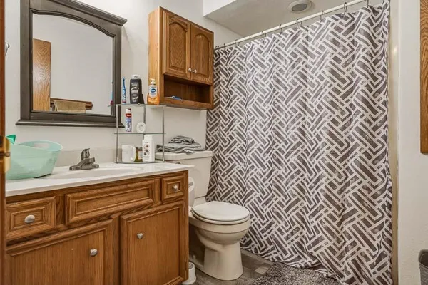 a bathroom with a granite countertop toilet sink and mirror