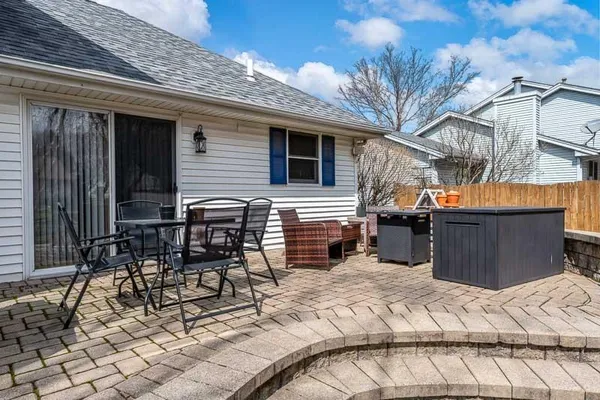 a view of a patio with a table and chairs and wooden fence