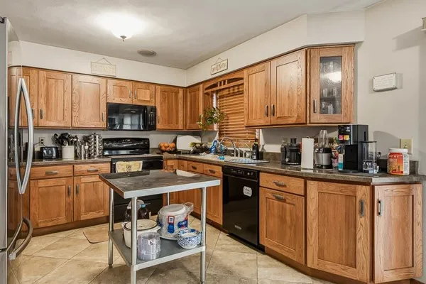 a kitchen with stainless steel appliances granite countertop a stove a sink dishwasher a microwave oven with cabinets and wooden floor