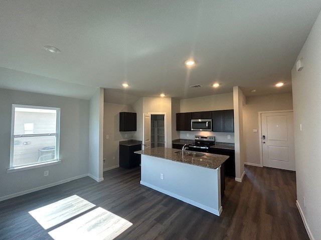 214 Perry Place Rockdale, TX 76567 - Photo 6 of 8 a kitchen with stainless steel appliances kitchen island granite countertop a stove a sink and a refrigerator