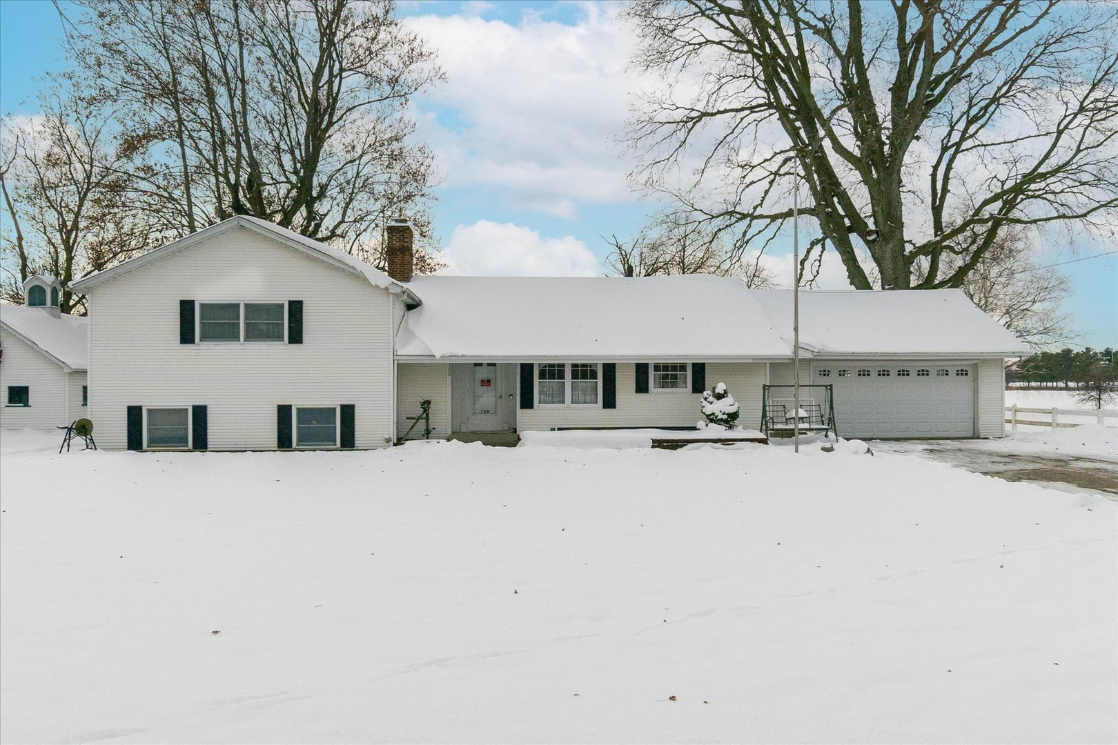 a front view of a house with a yard covered in snow
