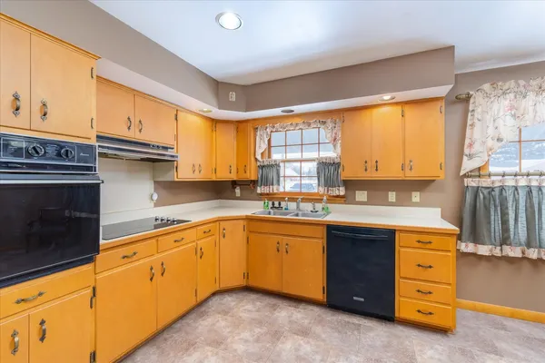 a kitchen with stainless steel appliances granite countertop a sink stove and cabinets