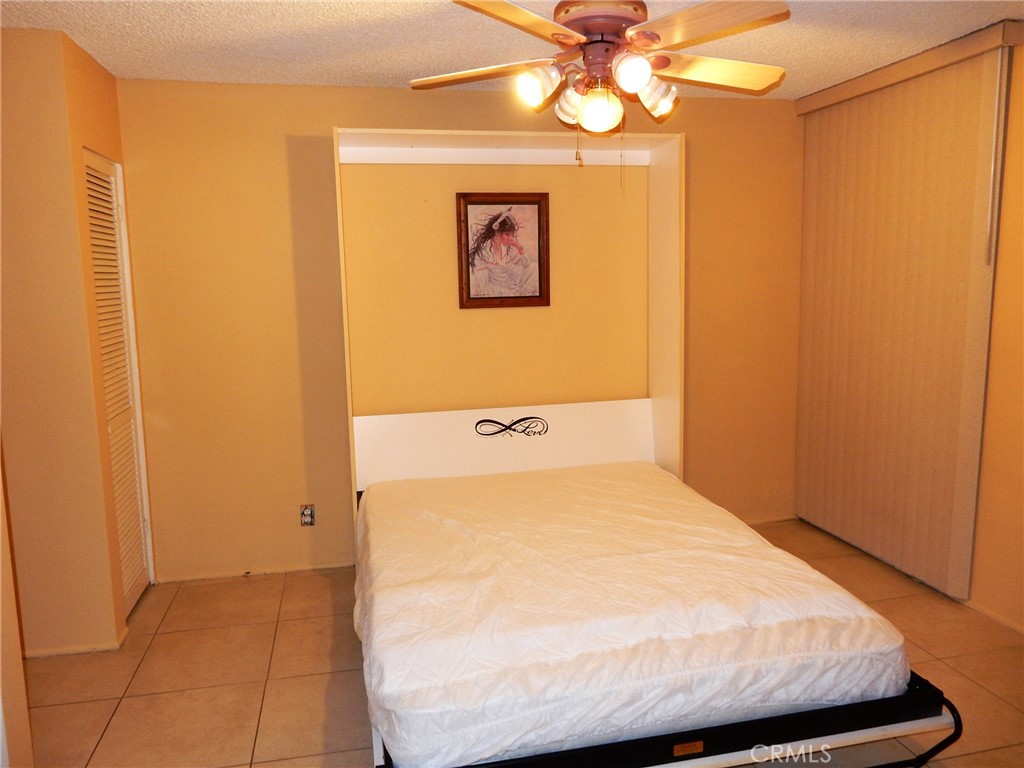 42278 Dunes View Road, Unit 28 Rancho Mirage, CA 92270 - Photo 21 of 57 a bedroom with a bed and a chandelier