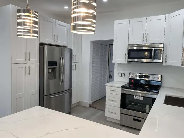a kitchen with stainless steel appliances a refrigerator stove and microwave