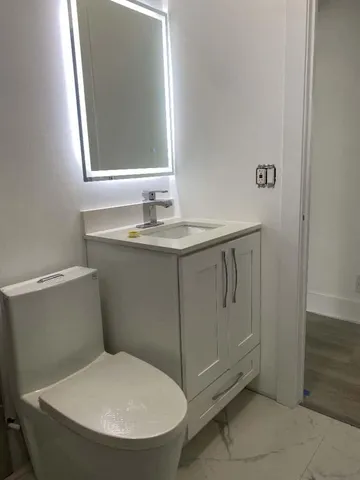 a bathroom with a toilet sink and mirror