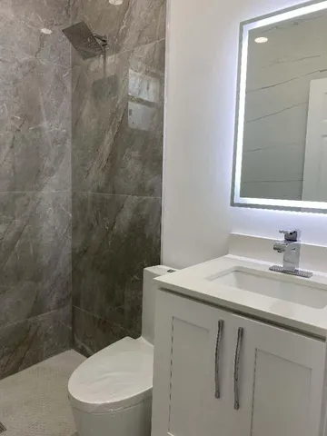 a bathroom with a sink a toilet and shower