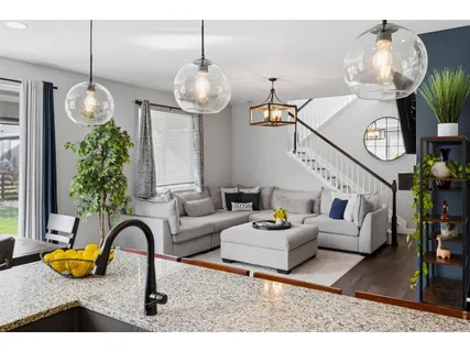 a living room with furniture chandelier and kitchen view