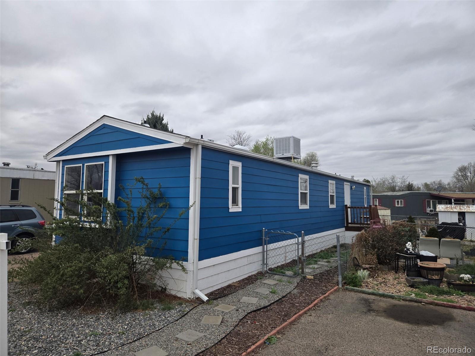1401 9th Street Fort Lupton, CO 80621 - Photo 3 of 4 a front view of a house with a garden