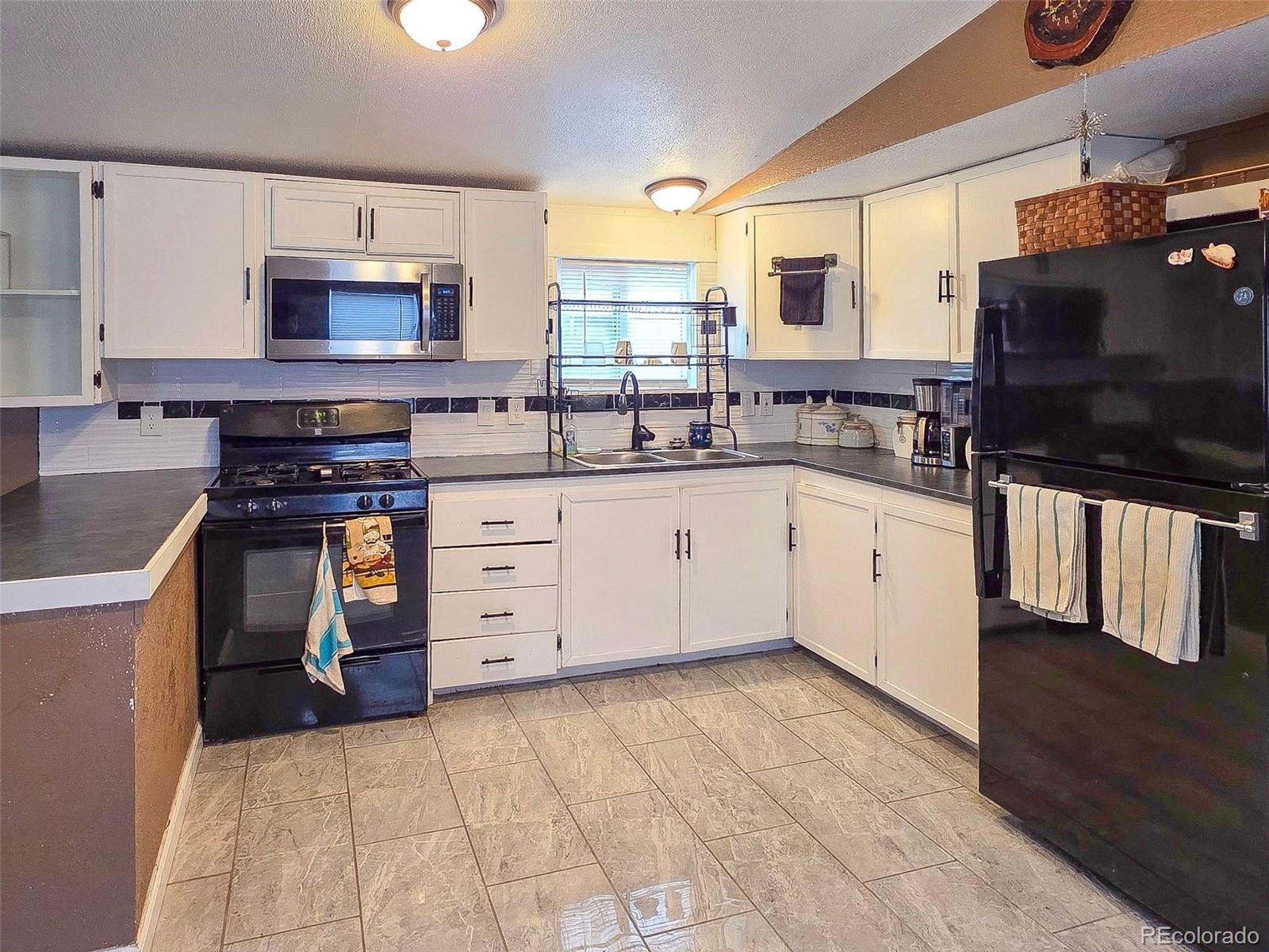 1401 9th Street Fort Lupton, CO 80621 - Photo 7 of 17 a kitchen with stainless steel appliances granite countertop a stove sink and cabinets