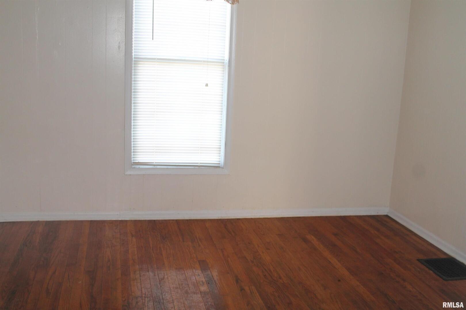 701 West Cherry Street, Unit 1 Carbondale, IL 62901 - Photo 4 of 9 an empty room with wooden floor and windows