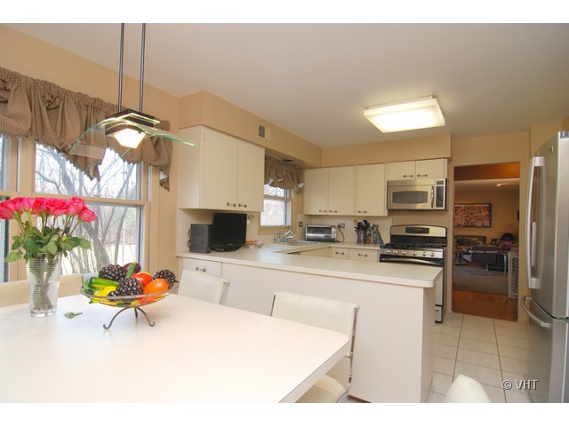 739 Sumac Road Highland Park, IL 60035 - Photo 3 of 10 a kitchen with stainless steel appliances kitchen island granite countertop a sink dishwasher a stove a refrigerator with a dining table and chairs