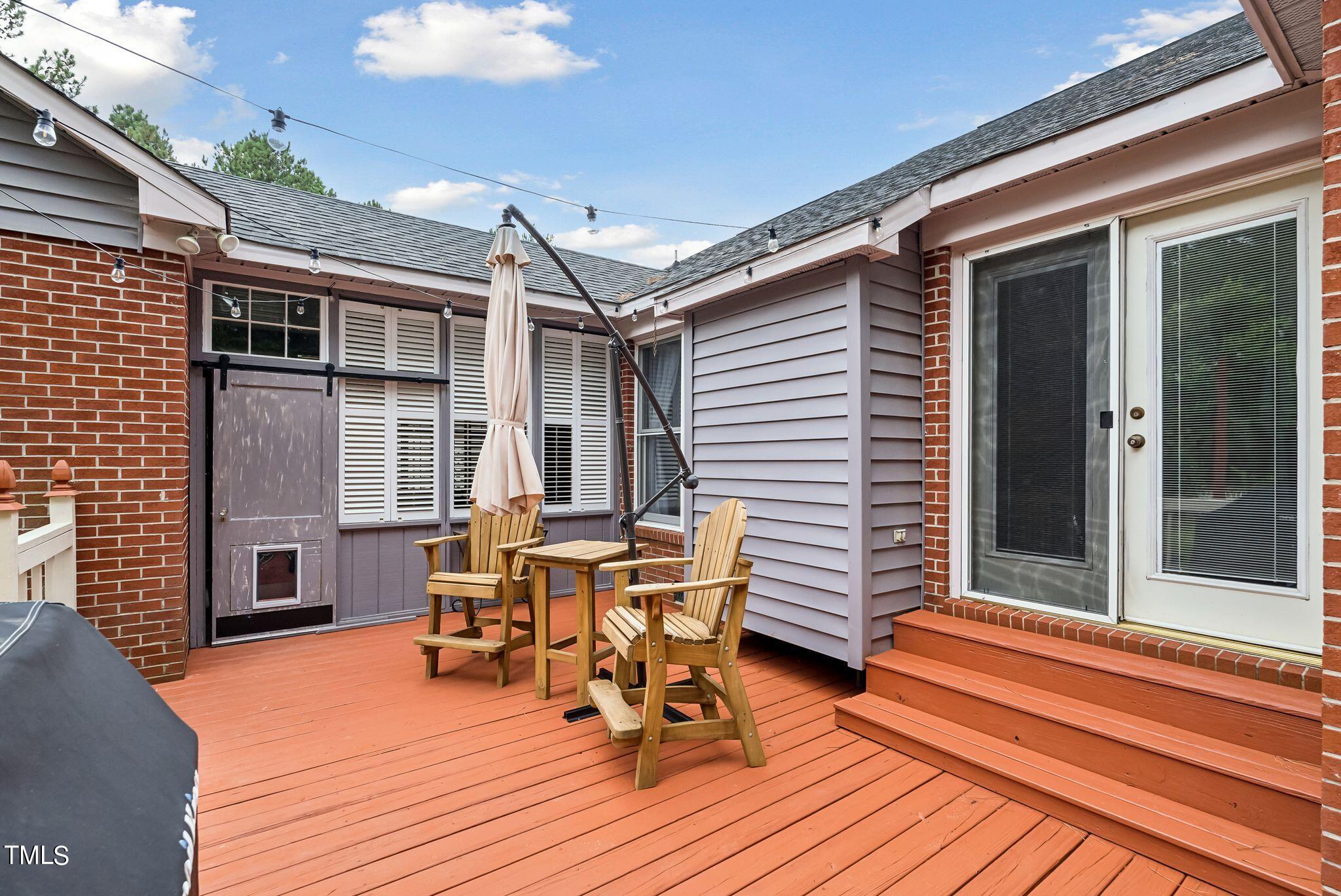 30341 East E Lake Rd Road Wagram, NC 28396 - Photo 29 of 39 a view of a patio with table and chairs with wooden floor and fence