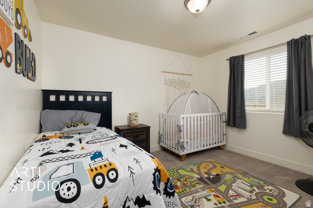 1713 South Windemere Road Santaquin, UT 84655 - Photo 18 of 40 Carpeted room featuring a window with horizontal blinds and dark curtains, a ceiling-mounted light fixture, and light-toned walls