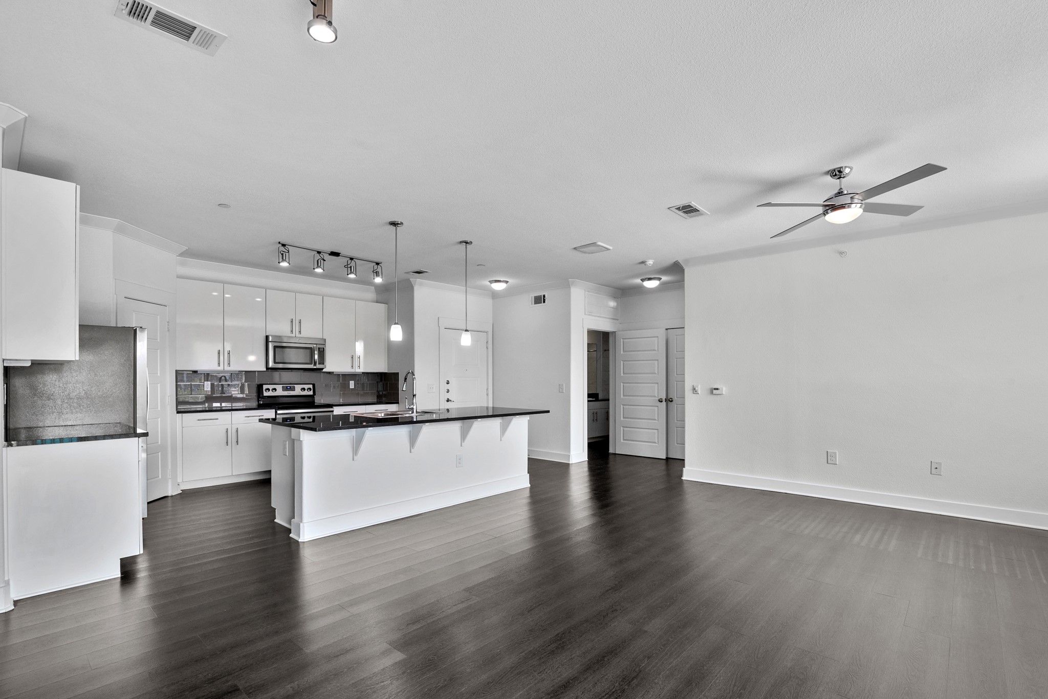 366 Fm 1488 Road, Unit 121 Conroe, TX 77384 - Photo 12 of 18 Kitchen with an island with sink, stainless steel appliances, white cabinets, a breakfast bar area, and backsplash