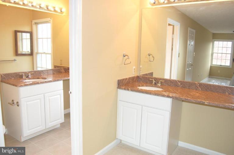 12600 Bridoon Lane Reston, VA 20191 - Photo 17 of 25 a bathroom with a granite countertop sink and a mirror