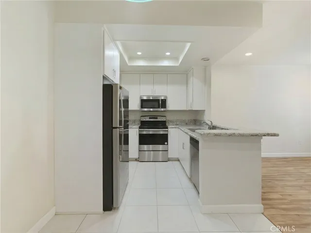 a kitchen with stainless steel appliances granite countertop a refrigerator and a stove