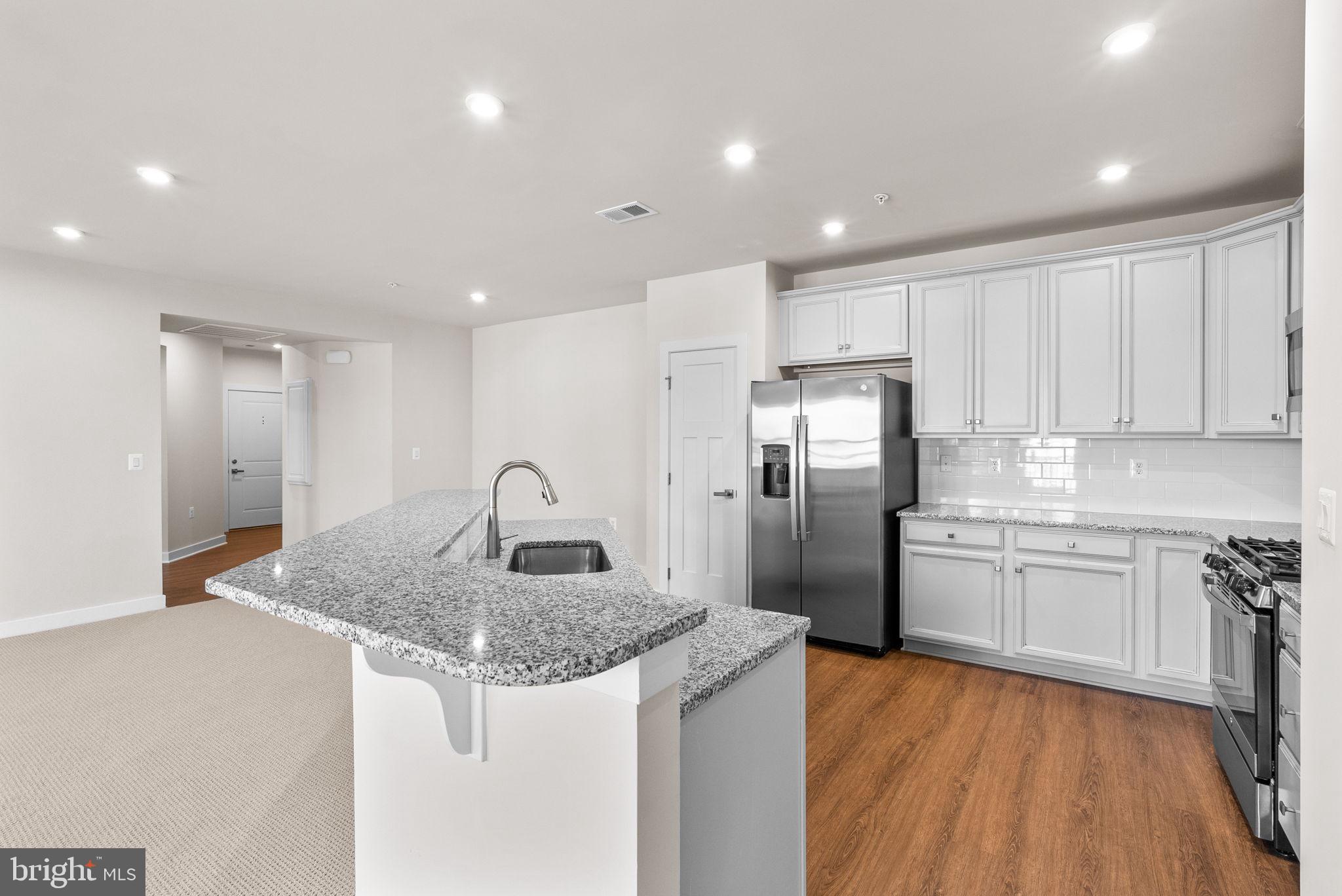 3520 Starlight Street, Unit 302 Frederick, MD 21704 - Photo 11 of 42 a kitchen with stainless steel appliances granite countertop a sink and a refrigerator