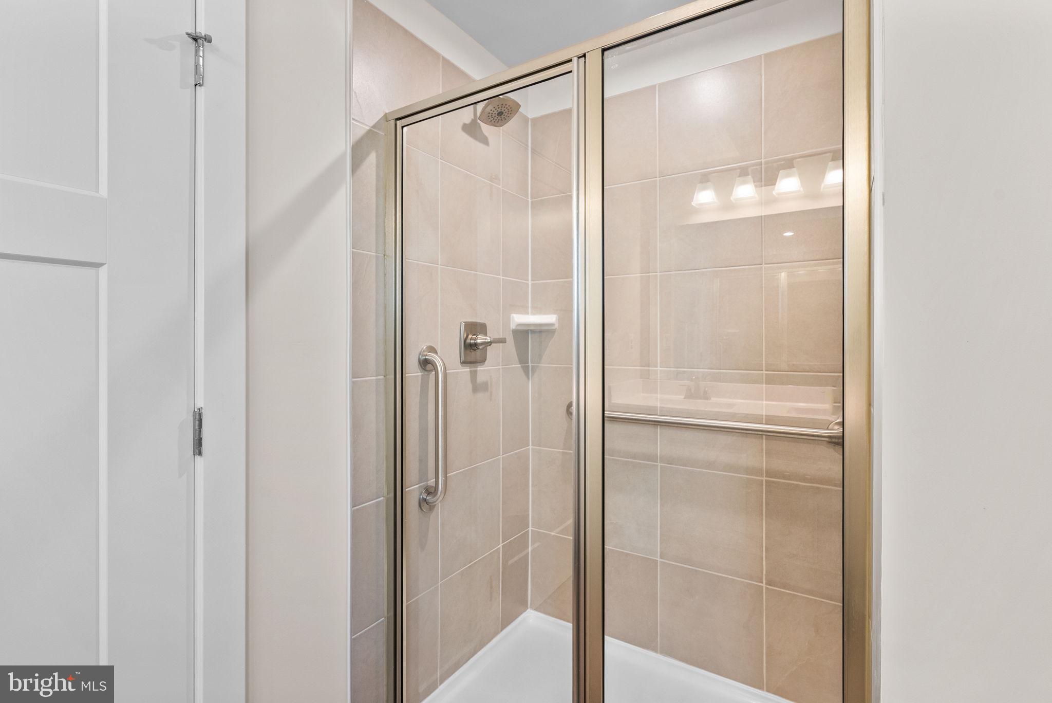 3520 Starlight Street, Unit 302 Frederick, MD 21704 - Photo 20 of 42 a bathroom with a glass shower door