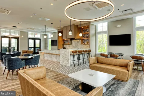 a living room with a table chairs and a flat screen tv