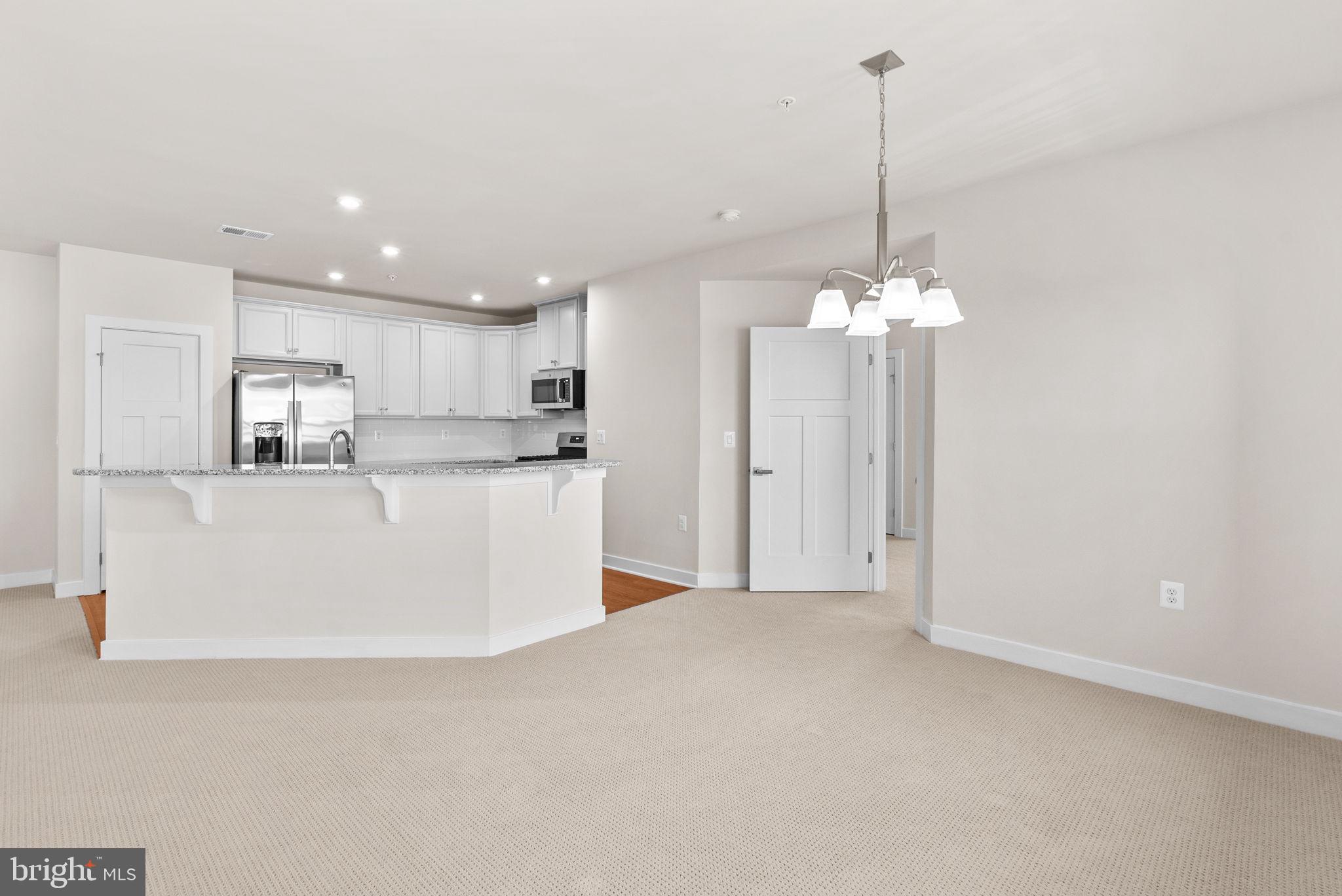 3520 Starlight Street, Unit 302 Frederick, MD 21704 - Photo 8 of 42 a view of a kitchen with refrigerator and white cabinets