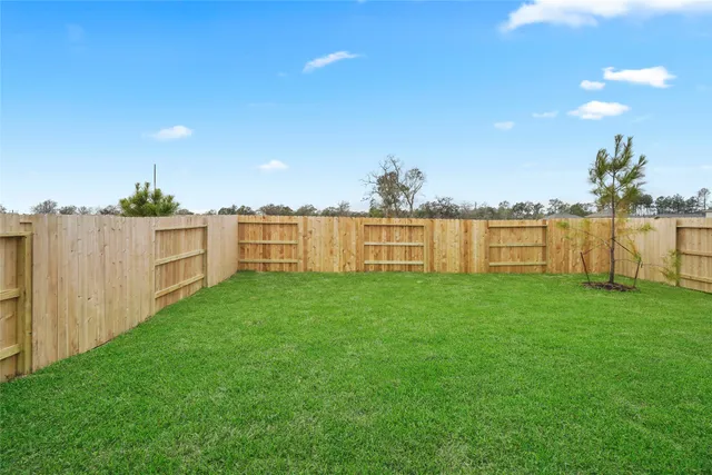 a view of a yard with a wooden fence