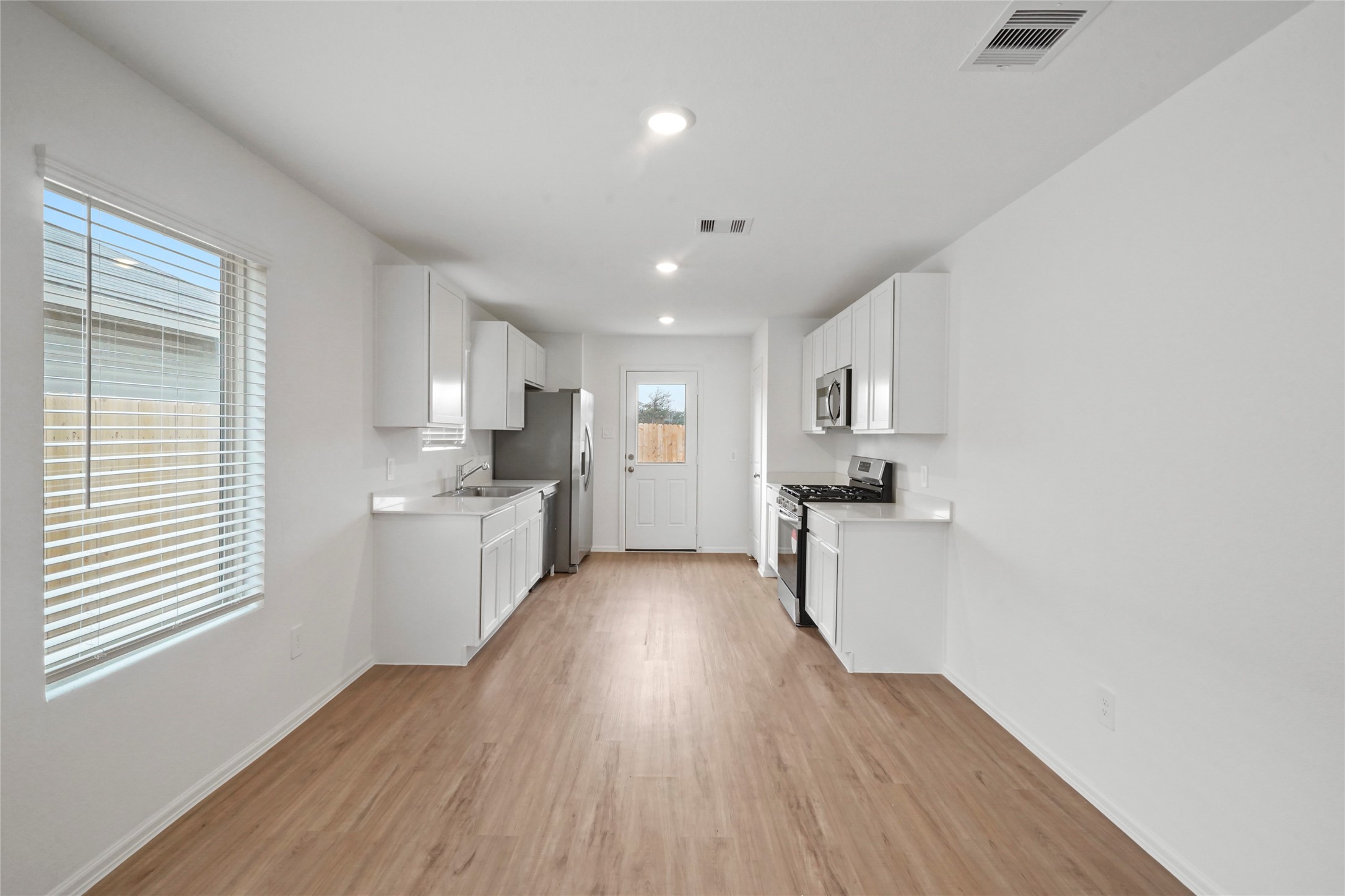 1440 Las Cuevas Drive Conroe, TX 77301 - Photo 4 of 25 a kitchen with a sink and wooden cabinets