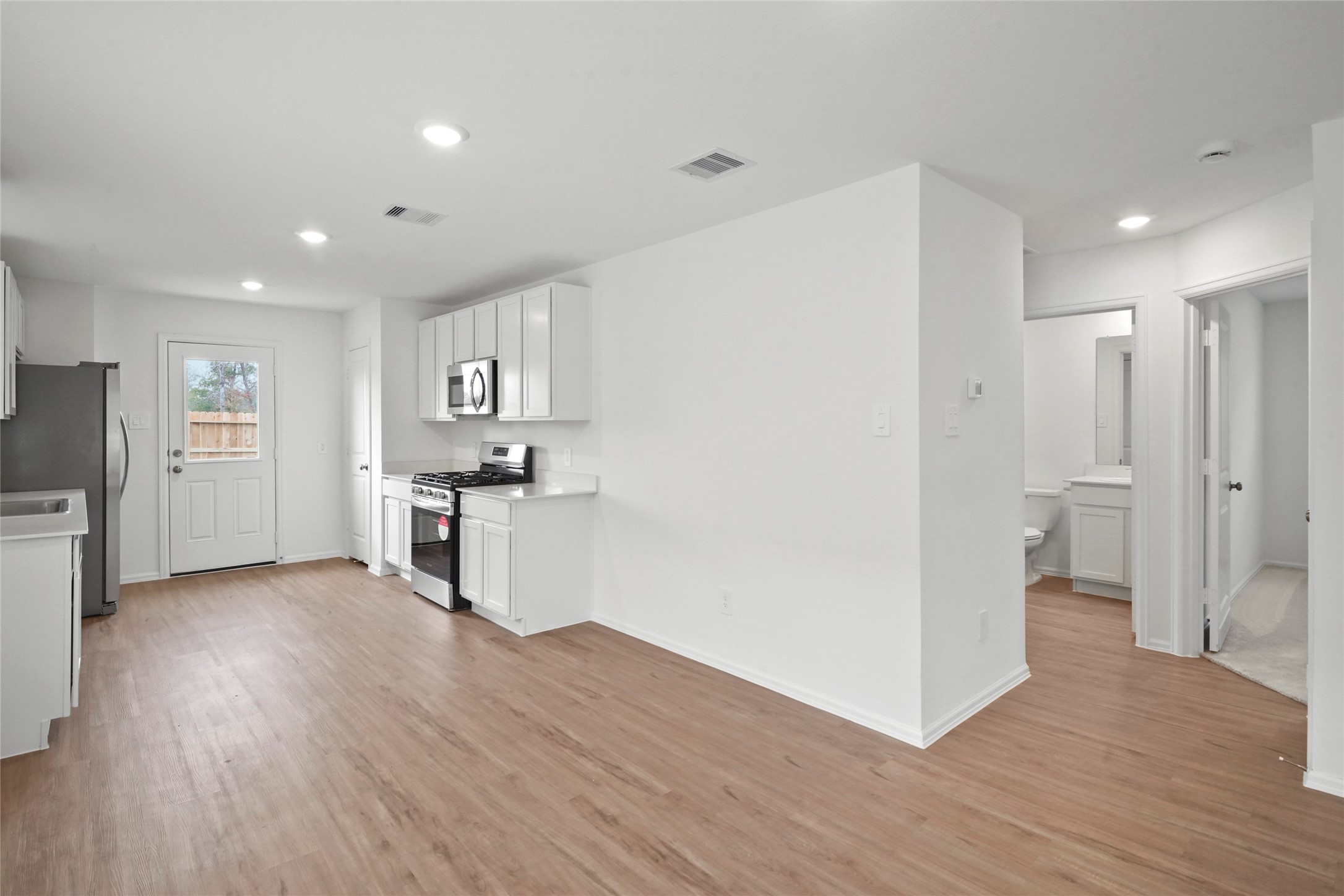 1440 Las Cuevas Drive Conroe, TX 77301 - Photo 5 of 25 a view of kitchen with refrigerator stove microwave and cabinets