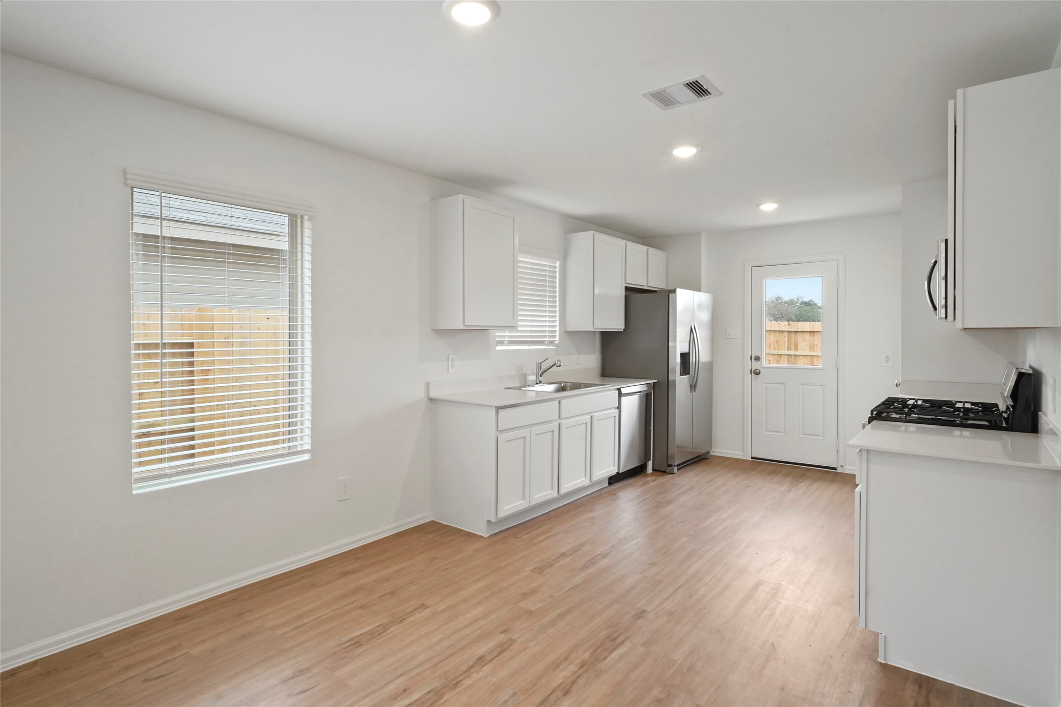 1440 Las Cuevas Drive Conroe, TX 77301 - Photo 6 of 25 a kitchen with wooden floors and white appliances