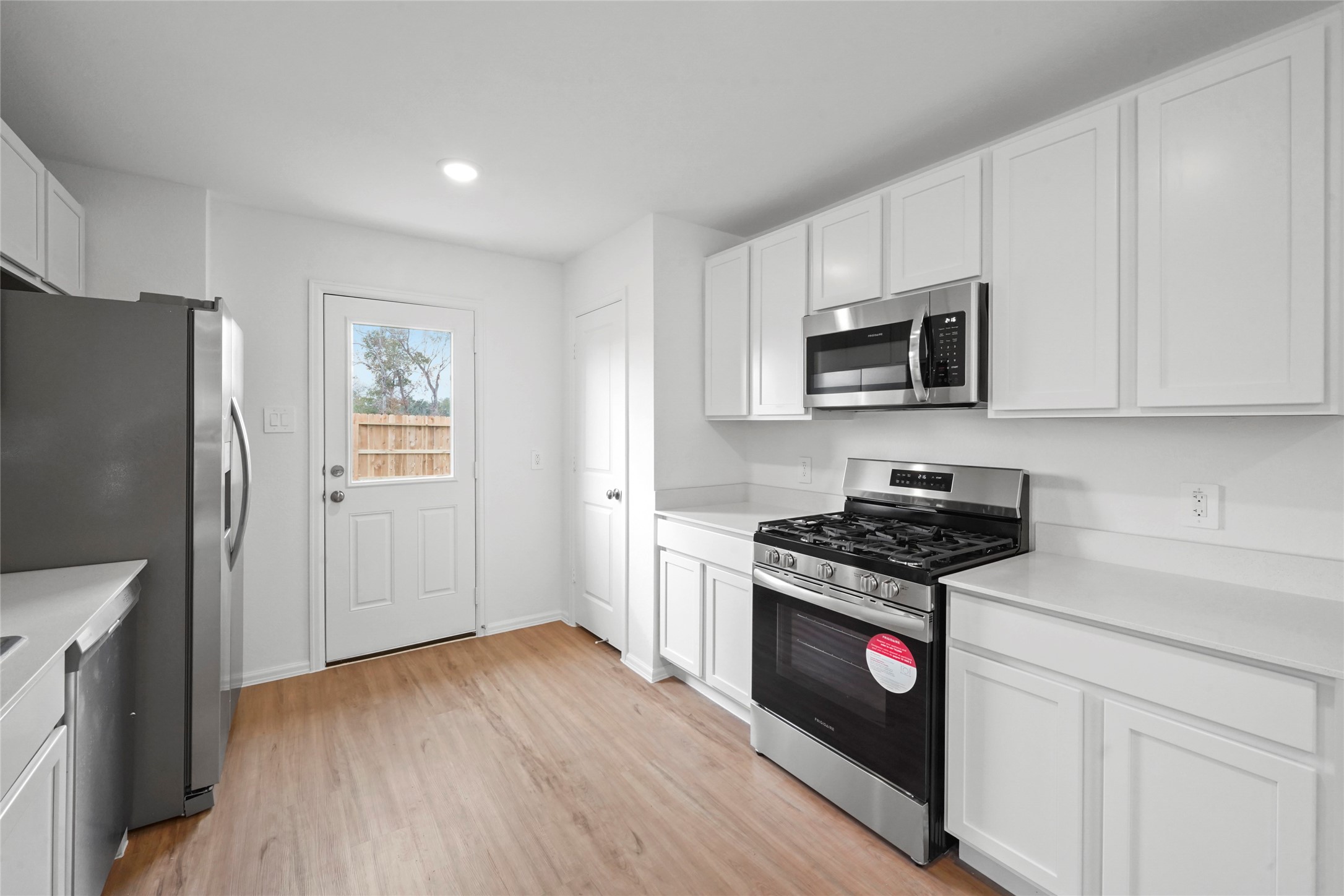 1440 Las Cuevas Drive Conroe, TX 77301 - Photo 7 of 25 a kitchen with stainless steel appliances a stove a microwave a sink and cabinets